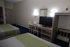 A hotel room with two beds, a desk with a television, and a chair.
