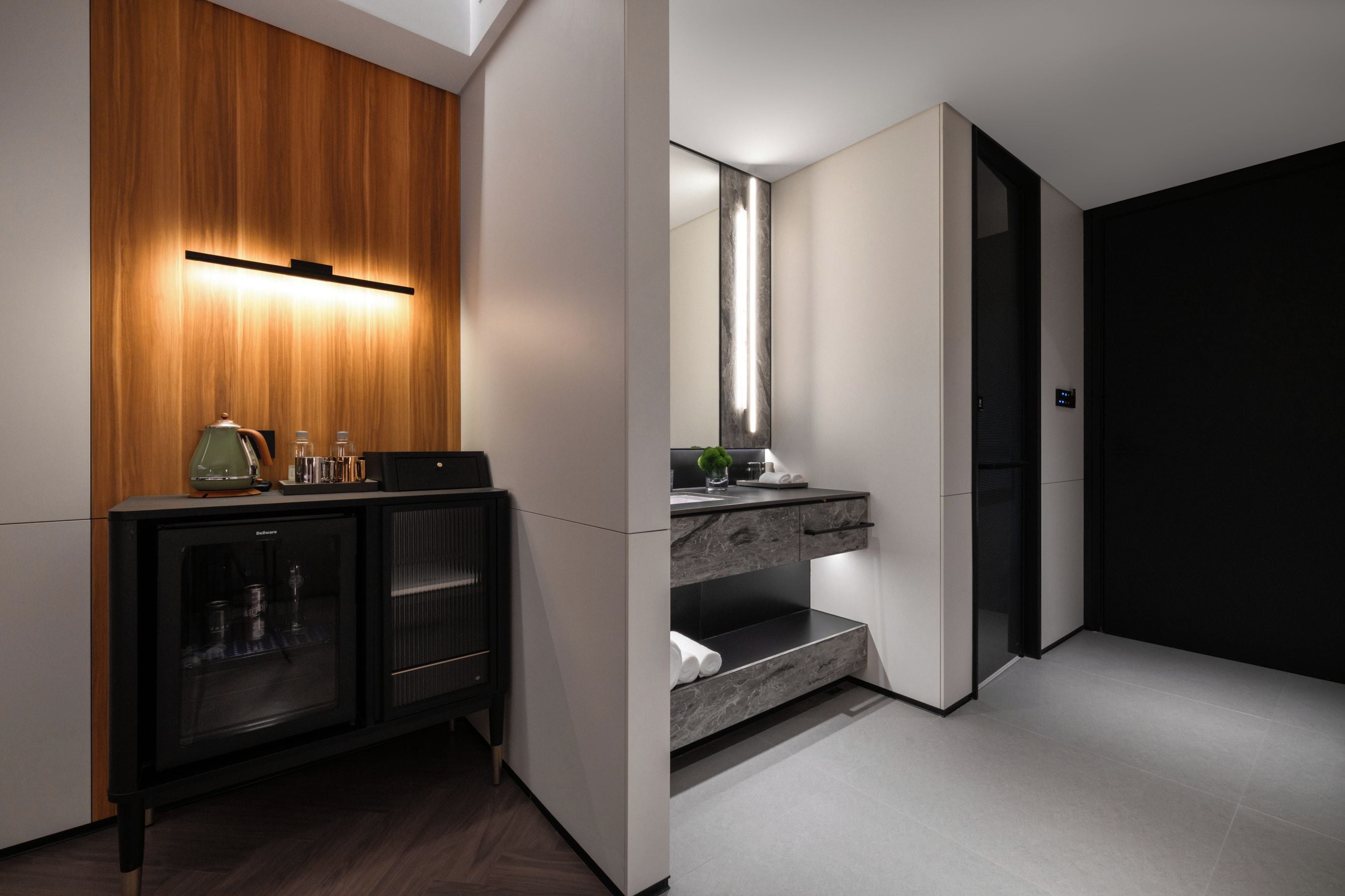 A modern bathroom with a wooden vanity, a built-in sink, and a large mirror.