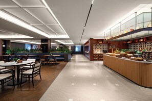 A modern restaurant with a long counter, seating area, and a high ceiling with recessed lighting. - IntercityHotel Shenzhen North Yifang (Shenzhen)