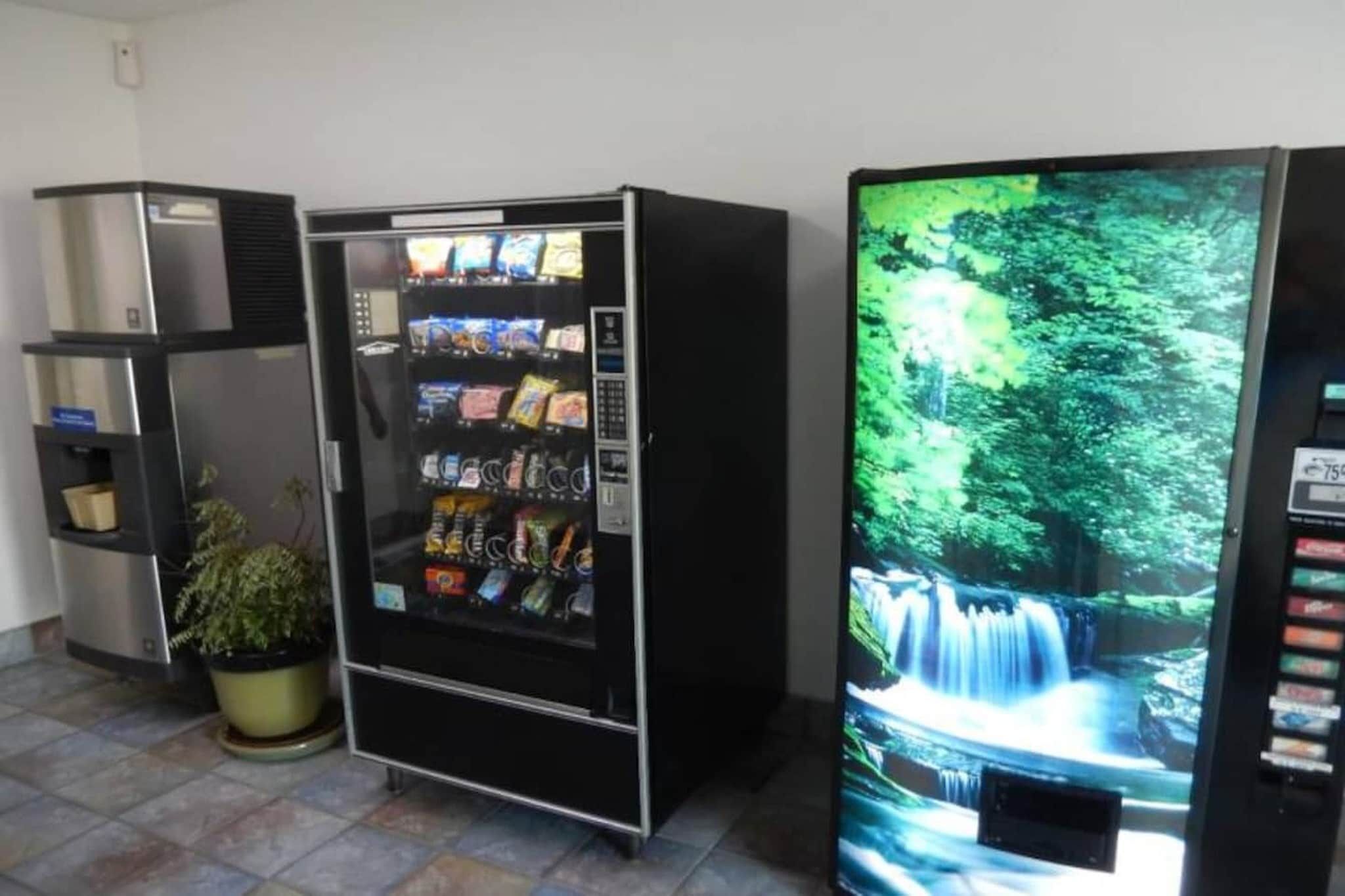 Ein Getränkeautomat mit Snacks und einem Bildschirm, der einen Wasserfall zeigt.