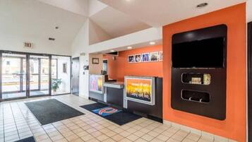 A reception area with a tiled floor, a reception desk, and a large screen displaying information.