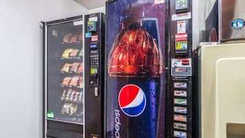 Ein Getränkeautomat mit Pepsi-Logo, einer Auswahl an Snacks und einer Bezahleinheit.