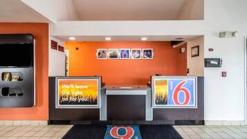 A hotel reception area with a counter, a digital display, and a floor number sign.