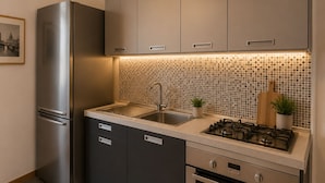 Una cucina moderna con frigorifero in acciaio inossidabile, piano cottura a gas e lavello.