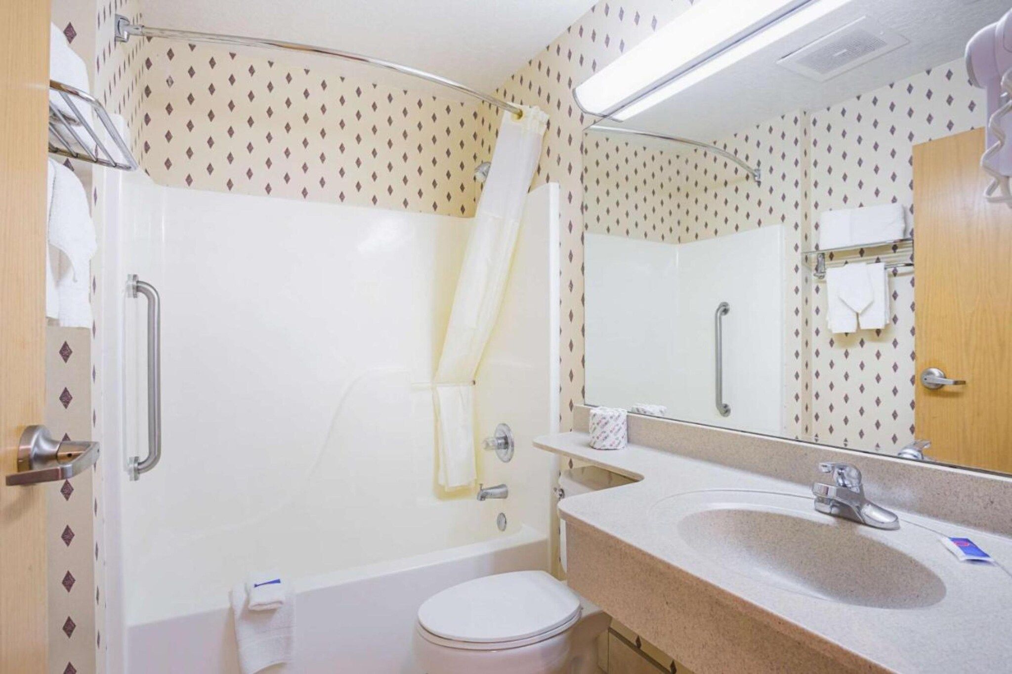 Ein Badezimmer mit Dusche, Toilette, Waschbecken und Spiegel.