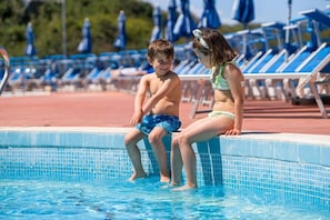A poolside area with lounge chairs and a tiled pool. - Carlton Hotel Riviera - Cefalu (Cefalù)