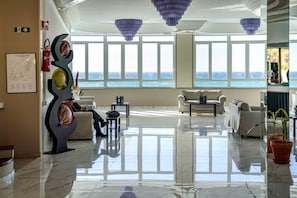 A spacious lobby with a view of the sea, modern furniture, and decorative elements. - Carlton Hotel Riviera - Cefalu (Cefalù)