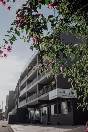 A multi-story building with balconies, a sign reading 'CITY PARK LIVING,' and a clear sky. - Mac & Sylvia Luxe Spa Bath City Escape (Launceston)