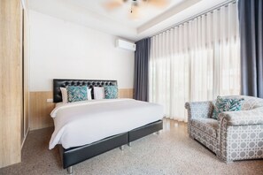 Une chambre d’hôtel avec un lit, un canapé et une fenêtre avec des rideaux.