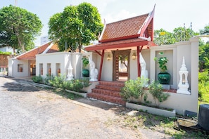 A row of traditional Thai houses with tiled roofs, white walls, and decorative statues. - Naka Pool Villa Pratumnak Pattaya (Pattaya City)
