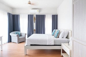 Een moderne slaapkamer met een bed, een stoel en een nachtkastje.