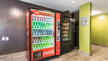 A vending machine area with a Coca-Cola branded machine stocked with beverages.