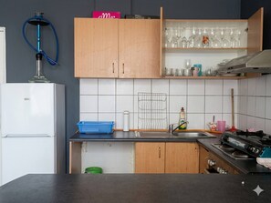 A kitchen with wooden cabinets, a sink, a stove, and a refrigerator. - Serene 1-bedroom Apartment in Central Cape Town (Cape Town)