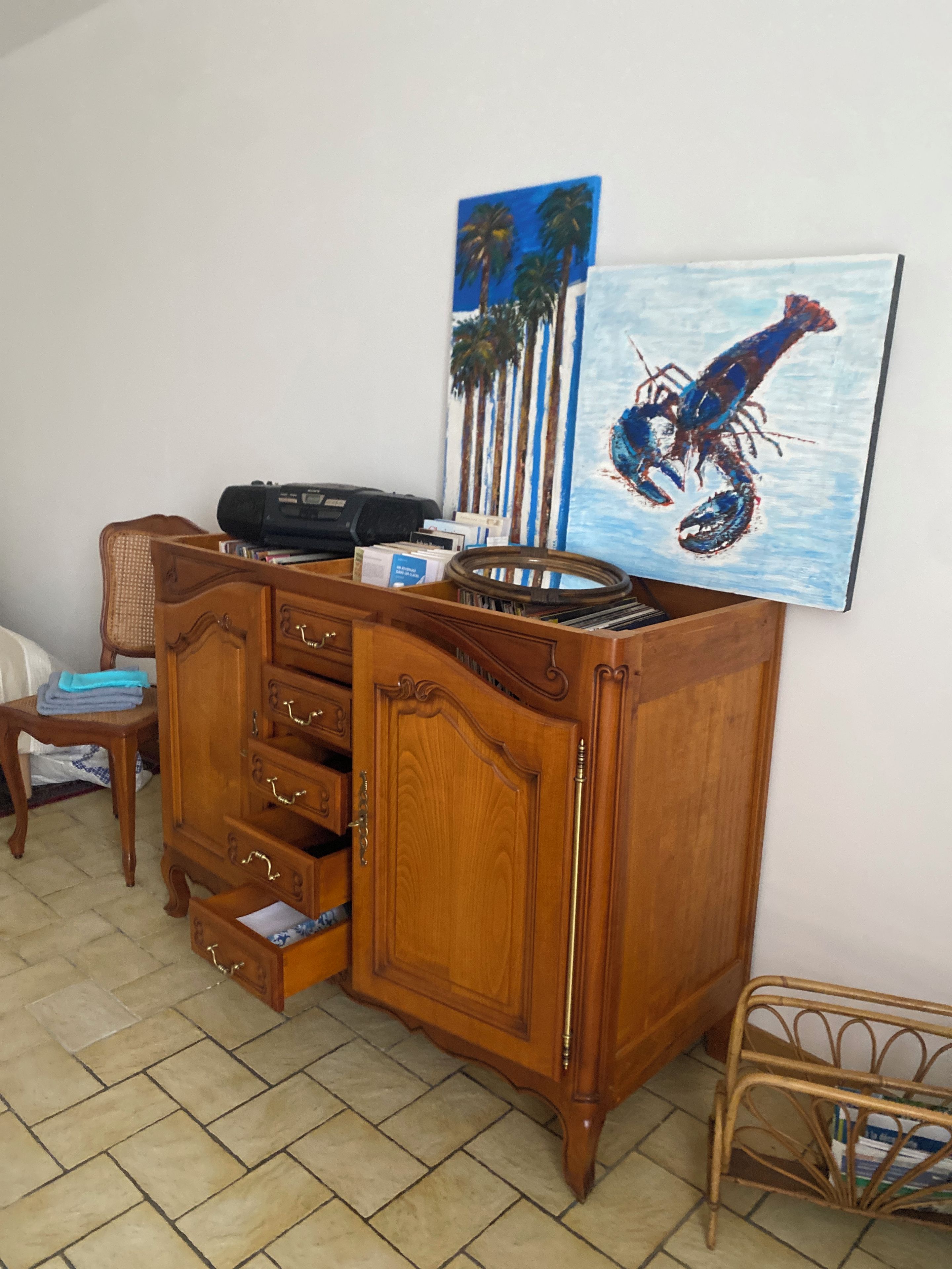 A wooden cabinet with drawers and a flat-screen TV mounted on the wall.