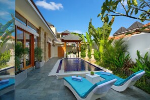 A modern outdoor pool area with lounge chairs and a pergola. - Holl Villa - Family Two Bedroom Villa (Kuta)