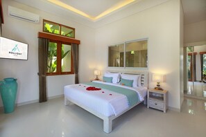 A hotel room with a bed, bedside tables, a large window, and a mirror. - Holl Villa - Family Two Bedroom Villa (Kuta)