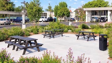 Un espace de stationnement équipé de tables de pique-nique et d’une poubelle.