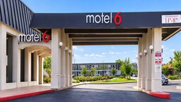 A motel with a covered parking area and a sign indicating a height clearance of 11'-8'.