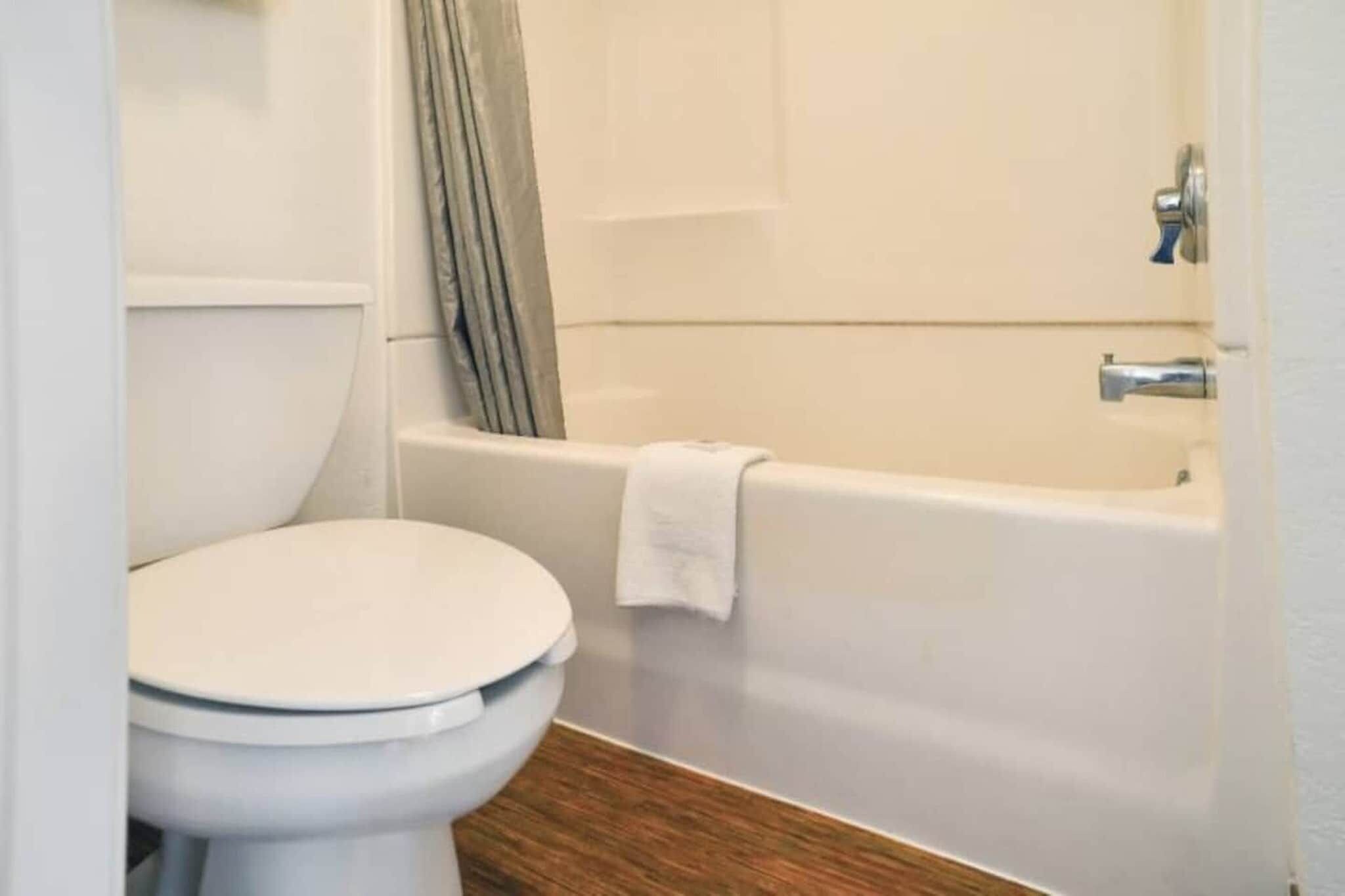 Un baño con inodoro, bañera y cortina de ducha.