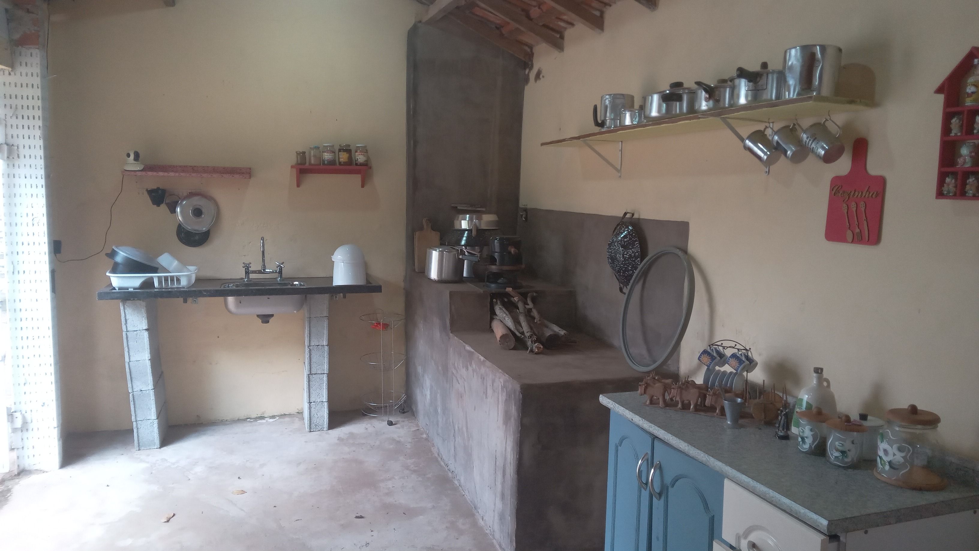 A kitchen with a sink, cabinets, and various kitchen utensils.