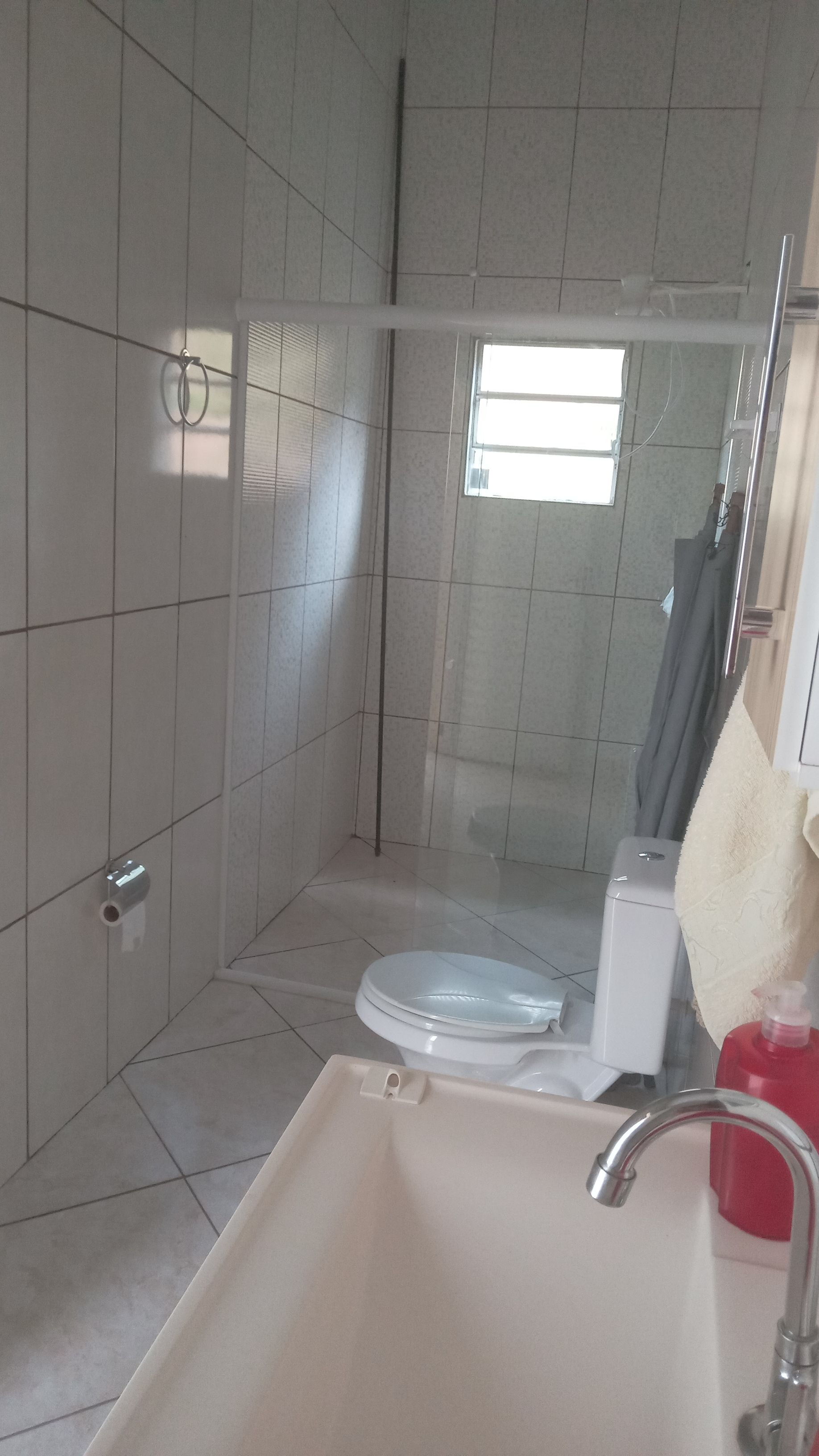 Une salle de bain comprenant des toilettes, un lavabo et un espace douche.