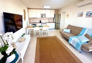 A compact living space with a kitchenette, a dining area, and a sofa. - Delightful 2-bedroom oceanview apartment with AC in Quarteira (Quarteira)