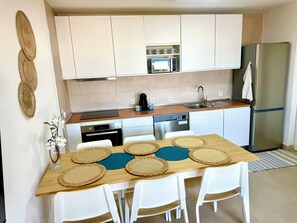 A modern kitchen with white cabinets, a stainless steel refrigerator, a microwave, and a dishwasher. - Delightful 2-bedroom oceanview apartment with AC in Quarteira (Quarteira)