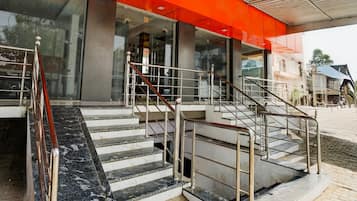 A staircase leading to a building with a red awning and a glass entrance.