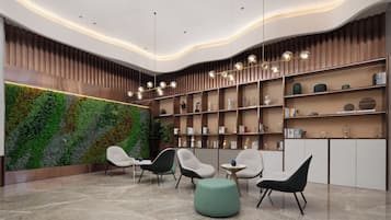 A modern reception area with a curved wall, a green vertical garden, and a collection of bookshelves.