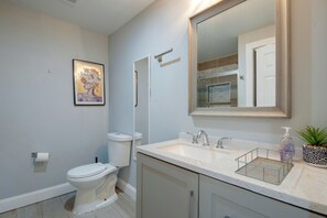 A bathroom with a toilet, sink, mirror, and a framed artwork on the wall. - < 1 Mi to MARTA! Extended Getaway 3 Mi to Dtwn (Atlanta)
