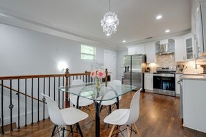 A modern kitchen with stainless steel appliances, a glass dining table, and white chairs. - < 1 Mi to MARTA! Extended Getaway 3 Mi to Dtwn (Atlanta)