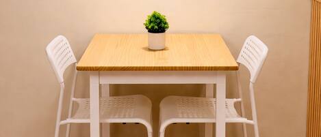 Une table à manger avec deux chaises, un luminaire suspendu et une petite plante en pot.