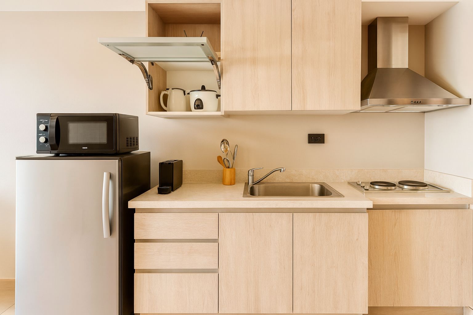 Una cocina moderna con microondas integrado, pileta de acero inoxidable y estufa.