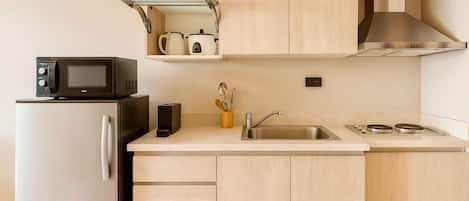 A modern kitchen with a built-in microwave, a stainless steel sink, and a stove.