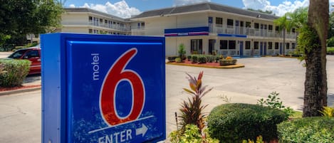 Señal de motel con un gran número 6 y una flecha que apunta a la derecha, mostrando la dirección de entrada.