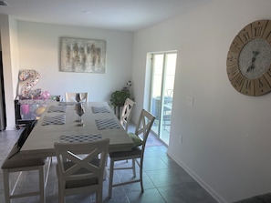 A dining area with a large table, chairs, and a wall clock. - 10 min from Lego land, the chain of lakes 45 min from Tampa& Disney (Eagle Lake)