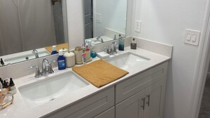 A bathroom with two sinks, a large mirror, and a towel rack. - 10 min from Lego land, the chain of lakes 45 min from Tampa& Disney (Eagle Lake)