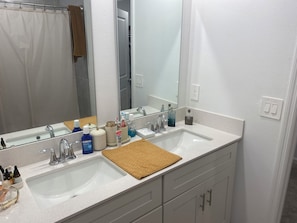 A bathroom with two sinks, a large mirror, and a towel rack. - 10 min from Lego land, the chain of lakes 45 min from Tampa& Disney (Eagle Lake)