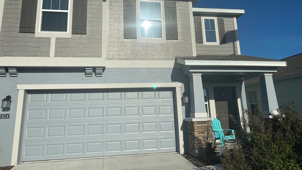 A two-story house with a garage, a covered porch, and a small front yard. - 10 min from Lego land, the chain of lakes 45 min from Tampa& Disney (Eagle Lake)