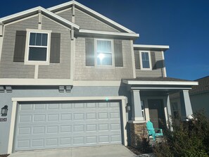 A two-story house with a garage, a covered porch, and a small front yard.