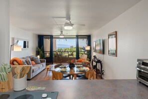 Ein modernes Wohnzimmer mit Essbereich, Deckenventilator und Blick ins Freie.