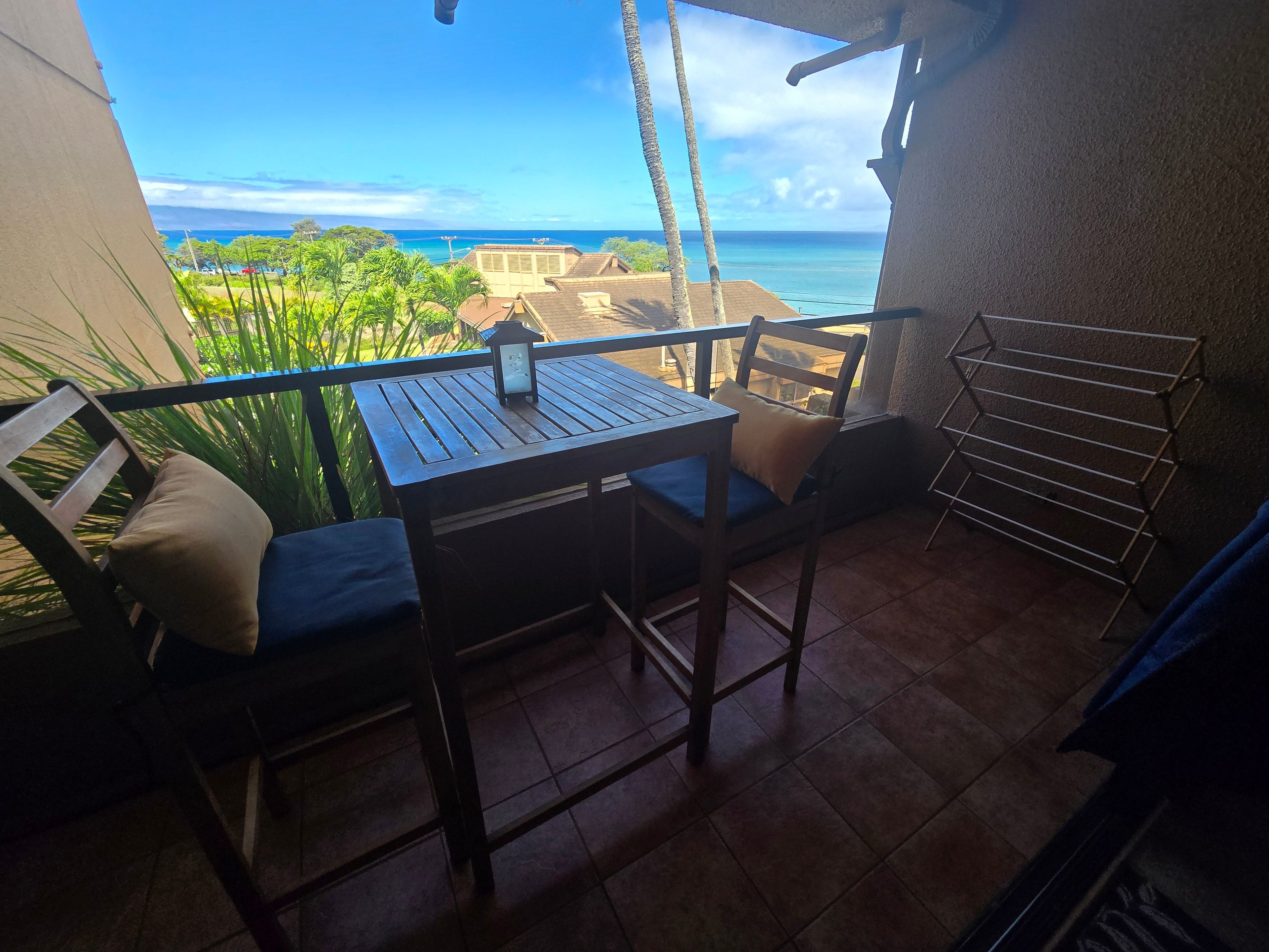 Ein Balkon mit Tisch und Stühlen, mit Blick auf die Küste.