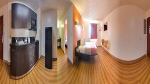 A compact hotel room with a kitchenette, a bed, and a bathroom. - Spacious King Bed|Free Wifi,Parking (Jonesboro)