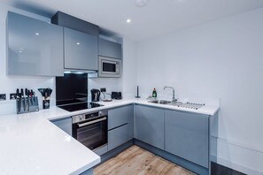 A modern kitchen with a microwave, stove, oven, and sink. - Stylish and Cosy 1 BDR Apt in Liverpool (Liverpool)