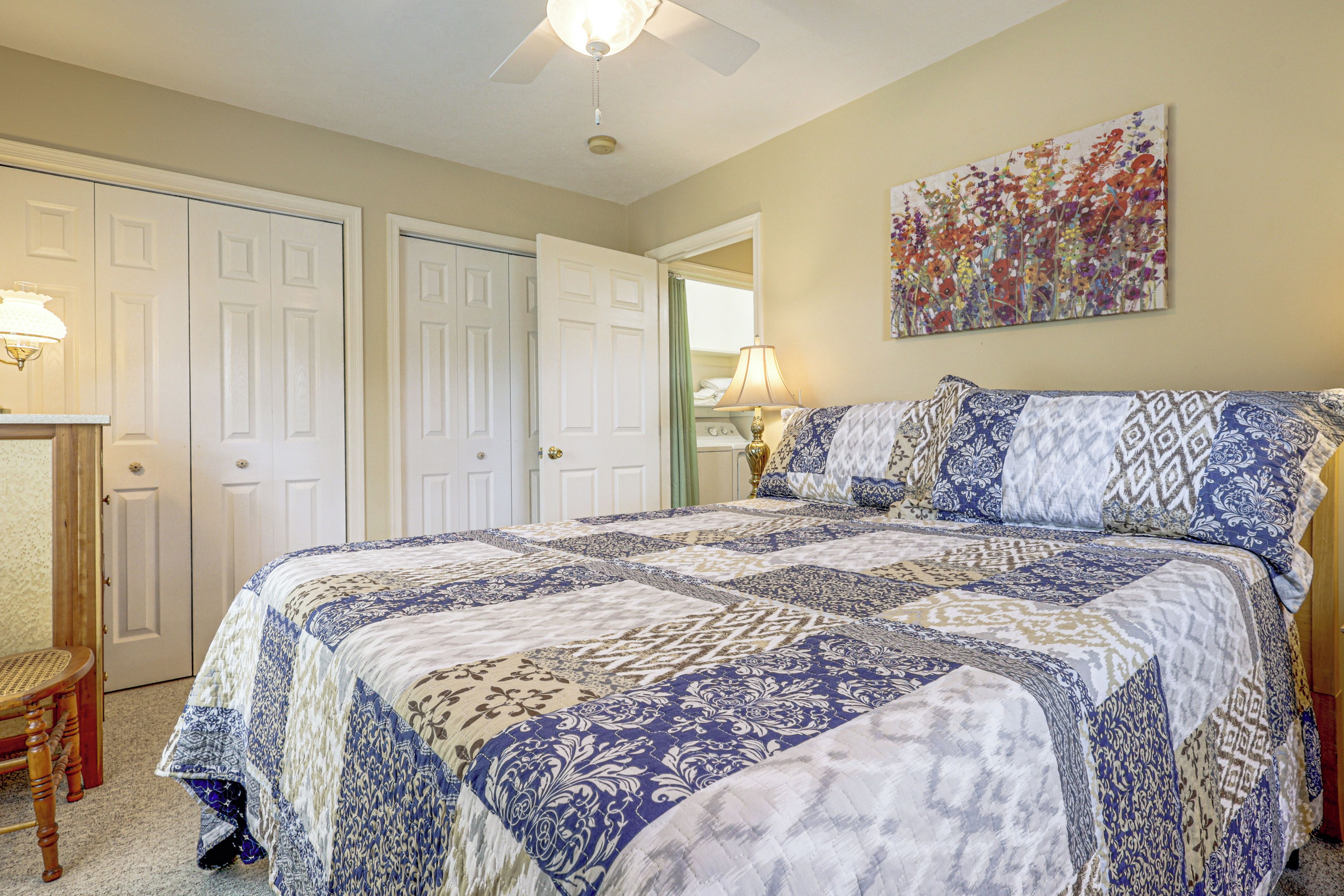 A bedroom with a large bed, a desk, and a chair.