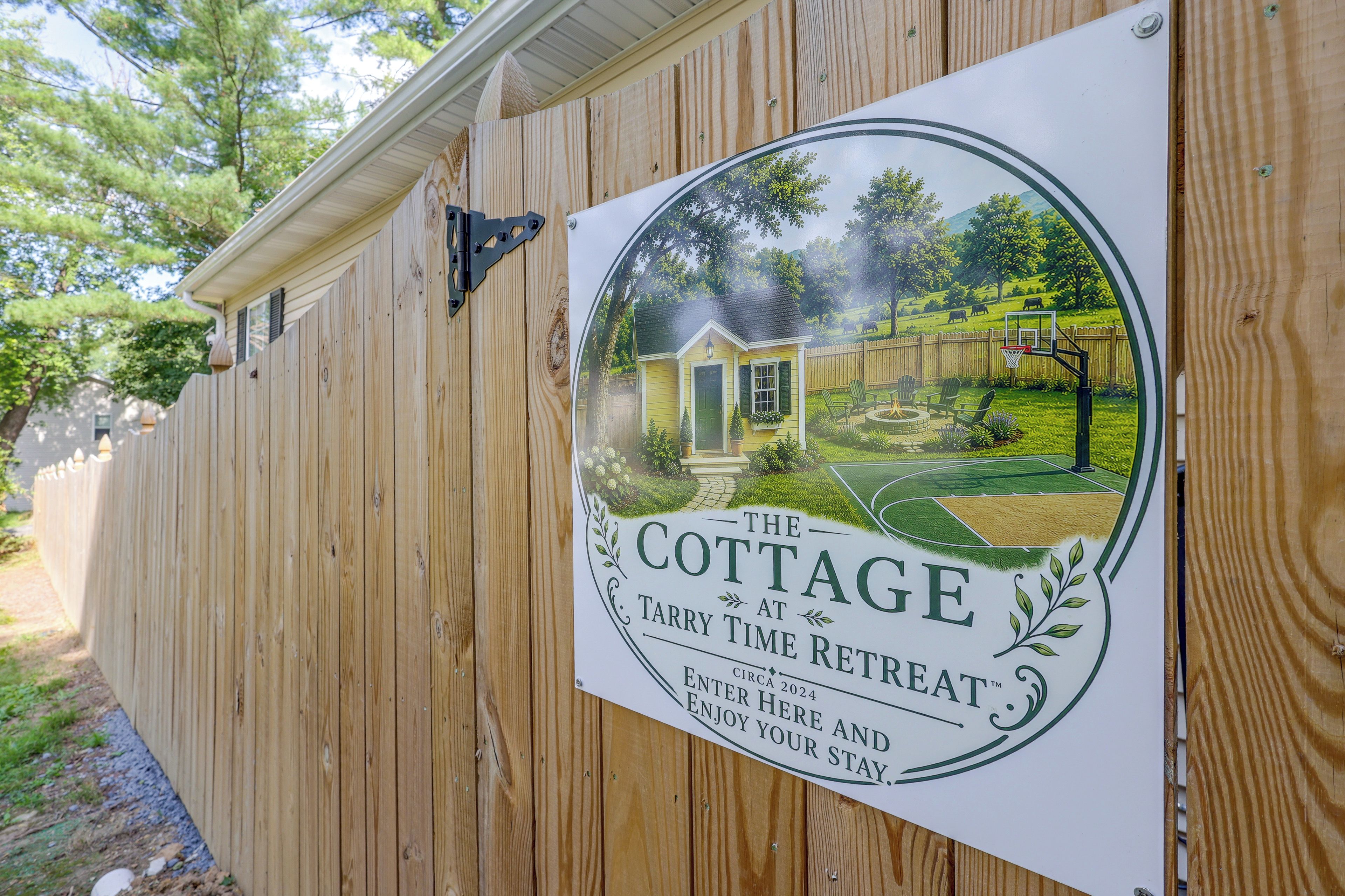 Une clôture en bois sur laquelle est affichée une pancarte publicitaire pour « The Cottage at Fairy Time Retreat ».