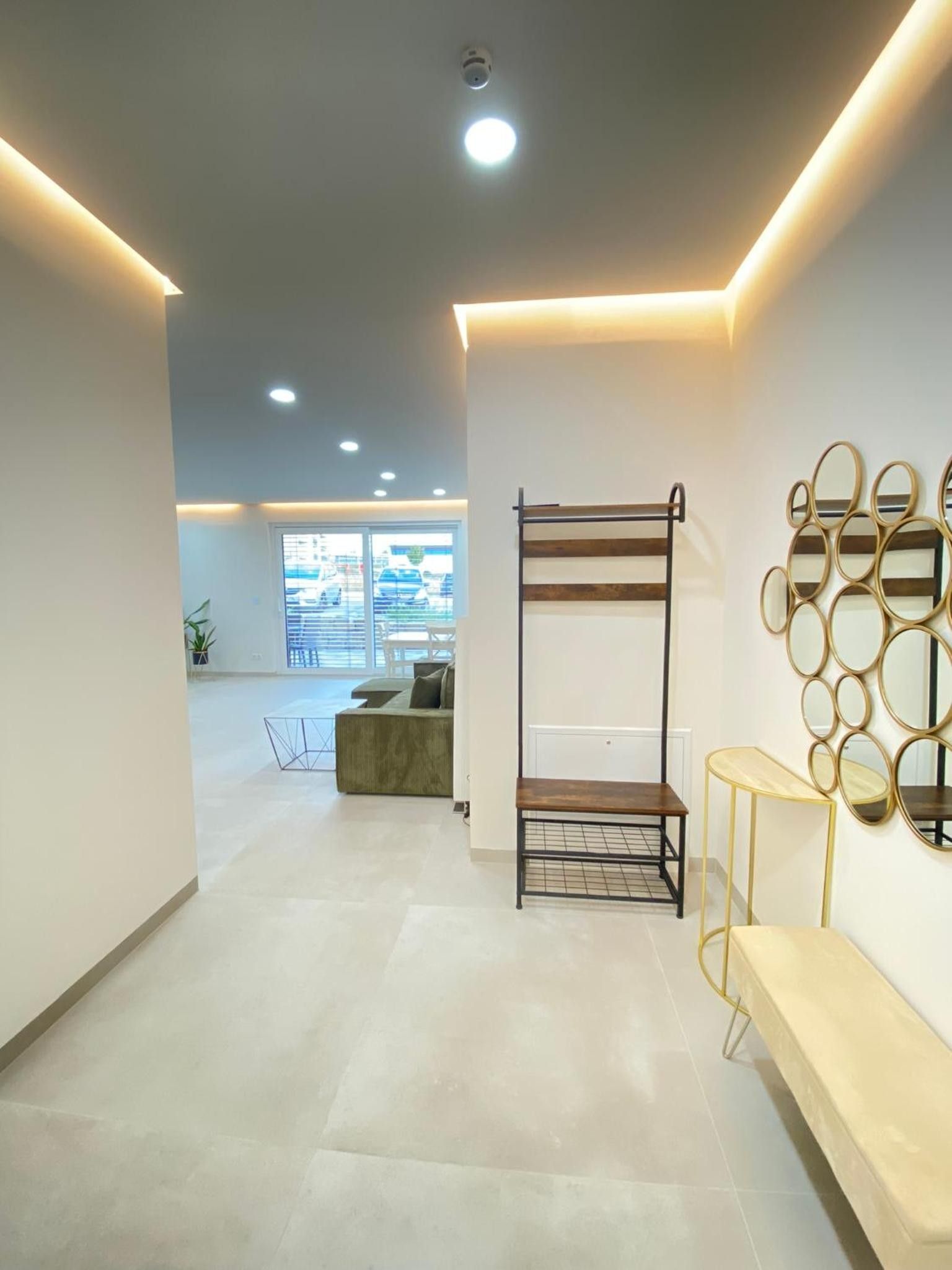 A modern interior with a bunk bed, a wall-mounted mirror, and a bench.