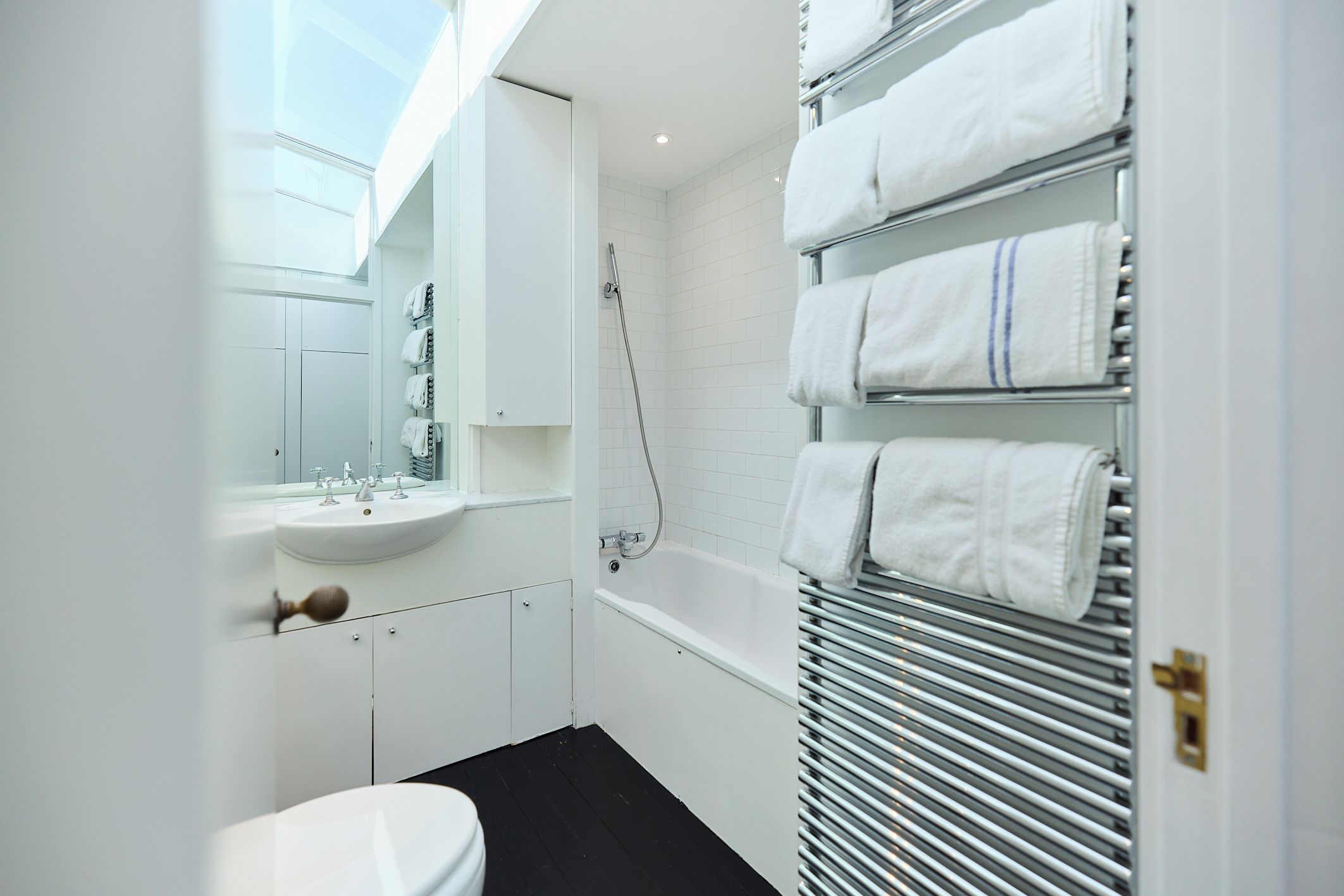 A modern bathroom with a white sink, mirror, and a bathtub.