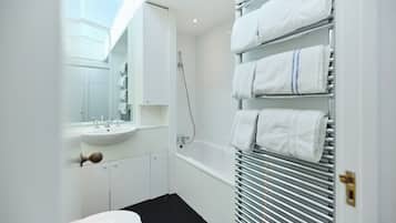 A modern bathroom with a white sink, mirror, and a bathtub.