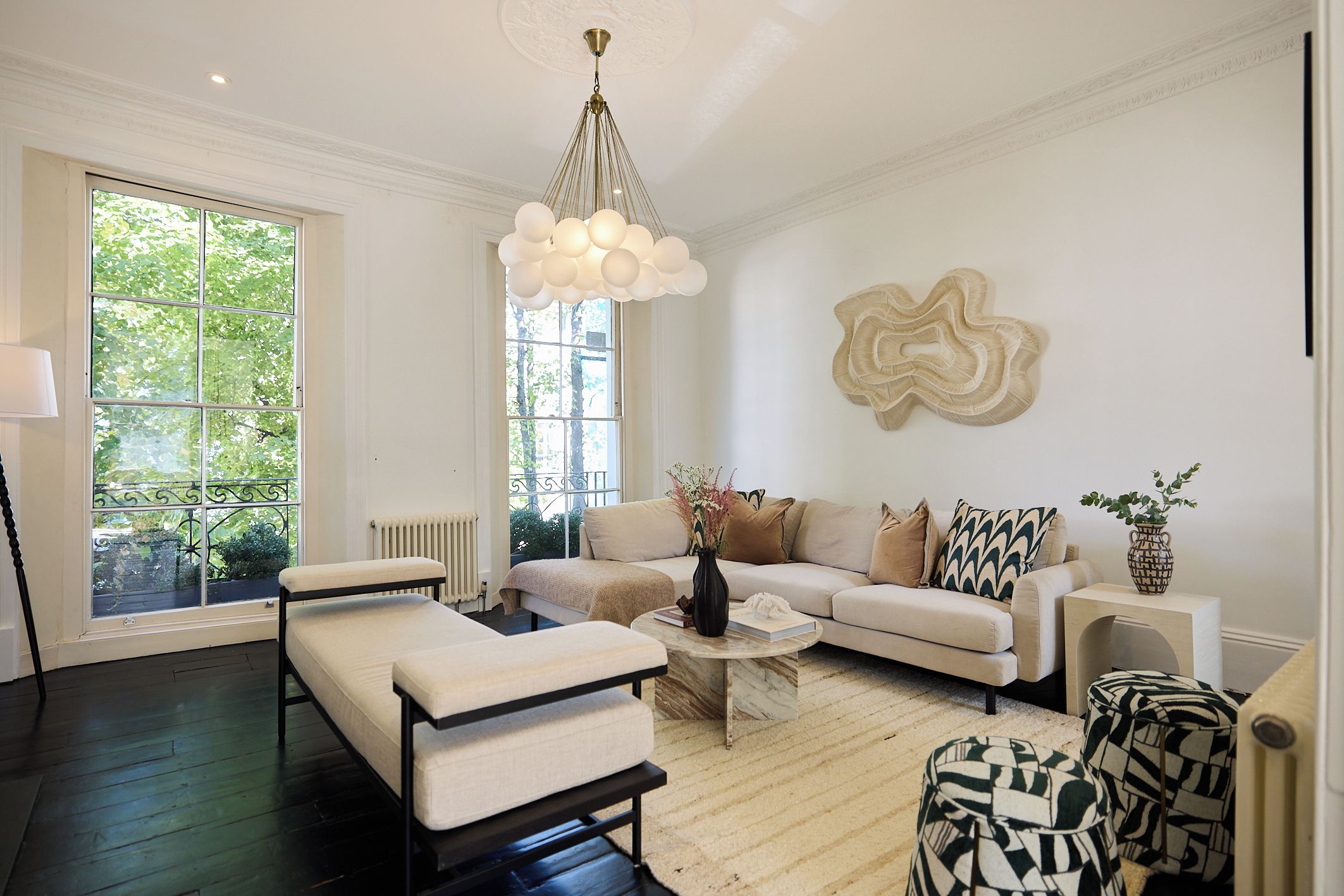 A modern living room with a sofa, coffee table, and a unique wall sculpture.